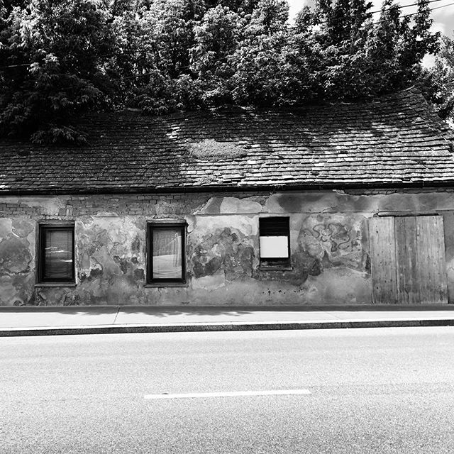 Schief. Also entweder ist das Haus schief oder der Gehsteig. Oder die Straße oder die Ausrichtung der Fenster zueinander - faszinierend finde ich, dass alle erlernte eine unterschiedliche Grundlinie haben. #crooked #vienna #simmering #architecture #instablackandwhite #blackandwhite #oldhouse #crookedstreet #horizon