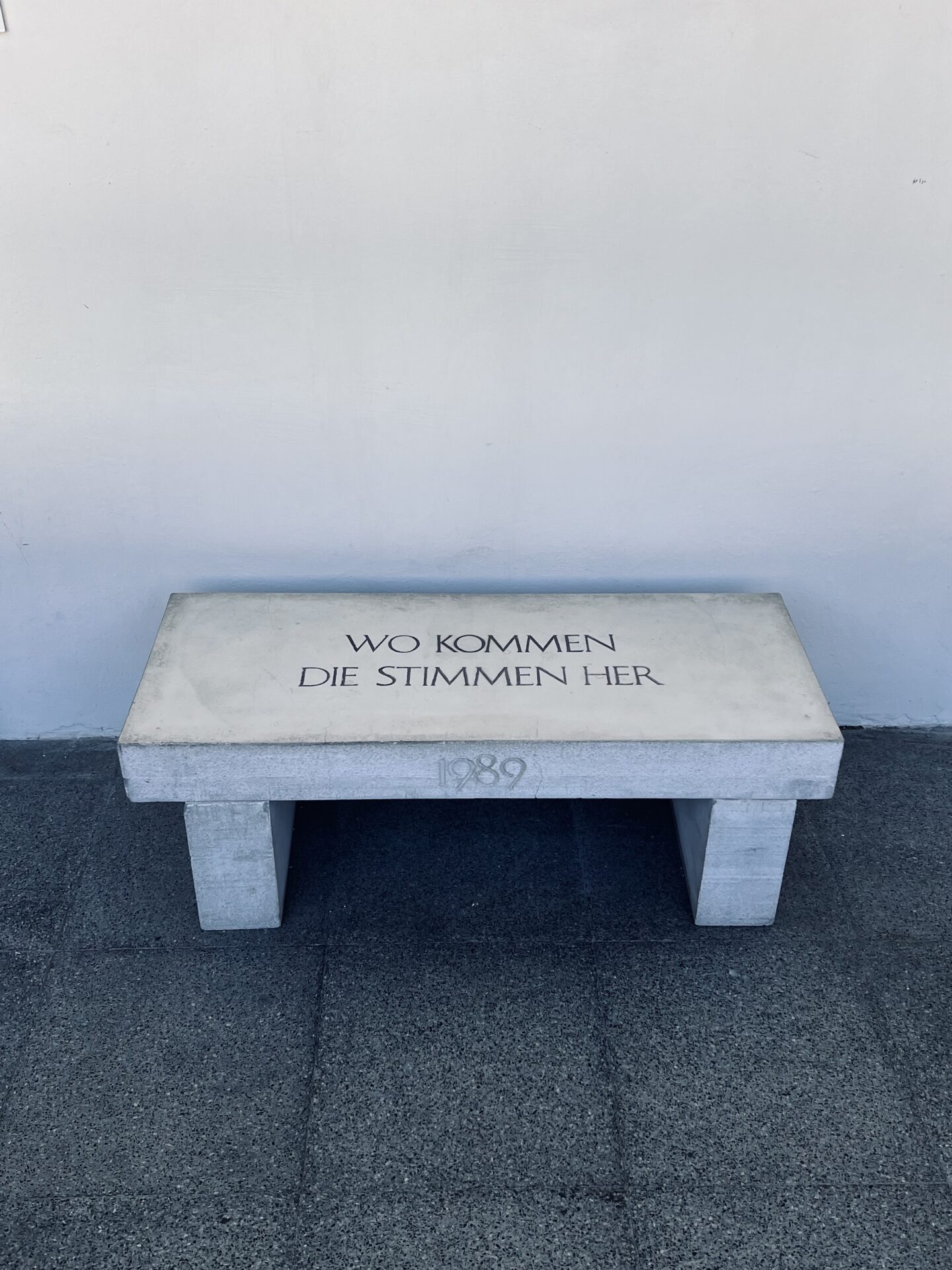 Sitzbank aus Beton mit der Inschrift "Wo kommen die Stimmen her"